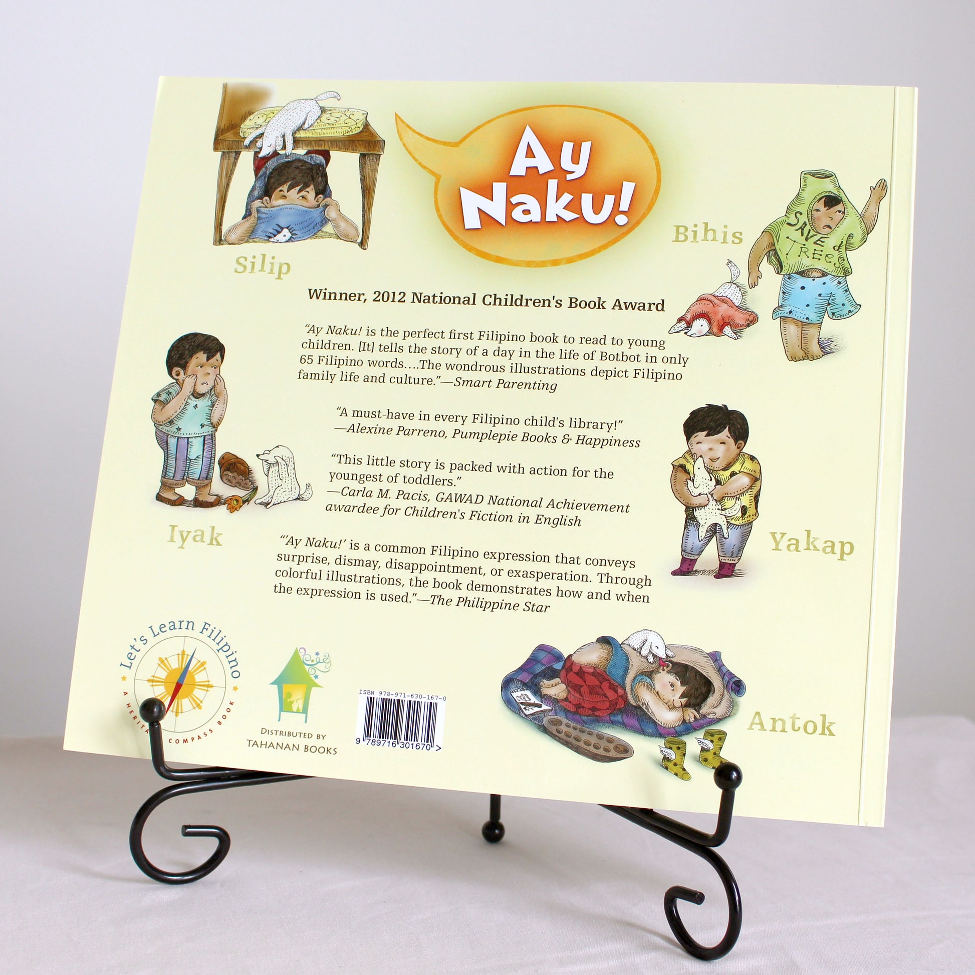 Children's book titled 'Ay Naku!' on a stand with illustrations and text.